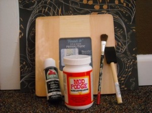 Arts and Crafts (wooden craft frame sits behind a tub of Mod Podge, paint and a foam and hair brush)