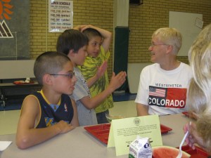Students and teacher speak in a school cafeteria