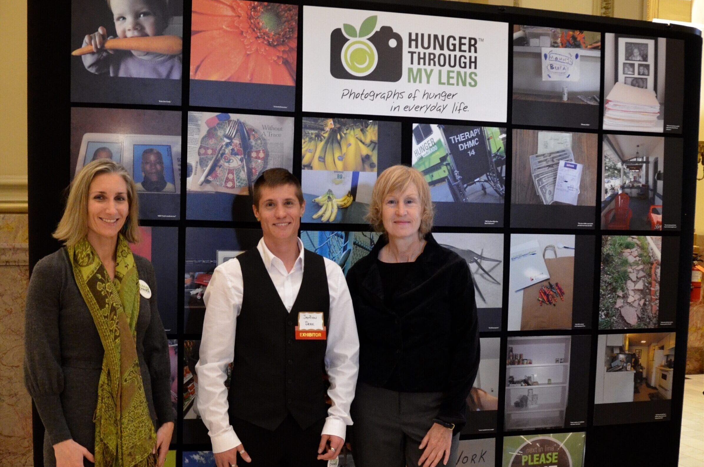 DSC_0204 three people standing in front of exhibit of hunger through my lens photos